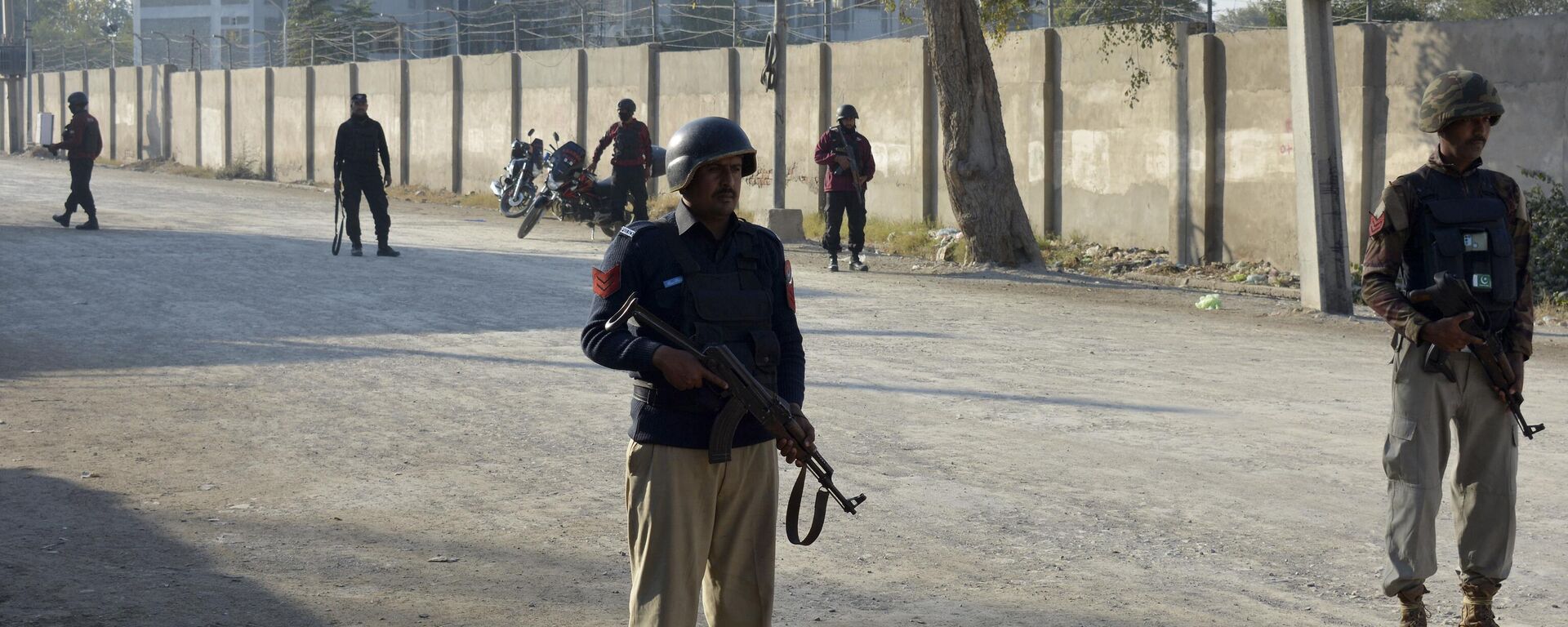 Security officials guard a blocked road leading to a counter-terrorism center after security forces starting to clear the compound seized earlier by Pakistani Taliban (banned in Russia) militants in Bannu, a northern district in the Pakistan's Khyber Pakhtunkhwa province, Tuesday, Dec. 20, 2022. - Sputnik India, 1920, 18.11.2023
