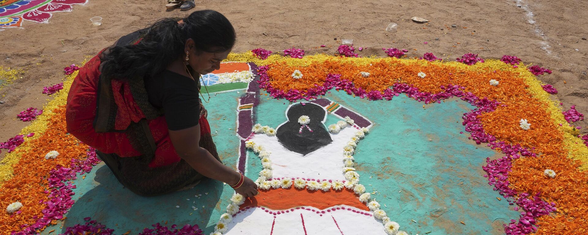 A woman prepares a Rangoli, a traditional art work of colored powder, during a rangoli competition on the eve of Makar Sankranti festival in Hyderabad, India, Friday, Jan. 13, 2023. - Sputnik India, 1920, 16.03.2023