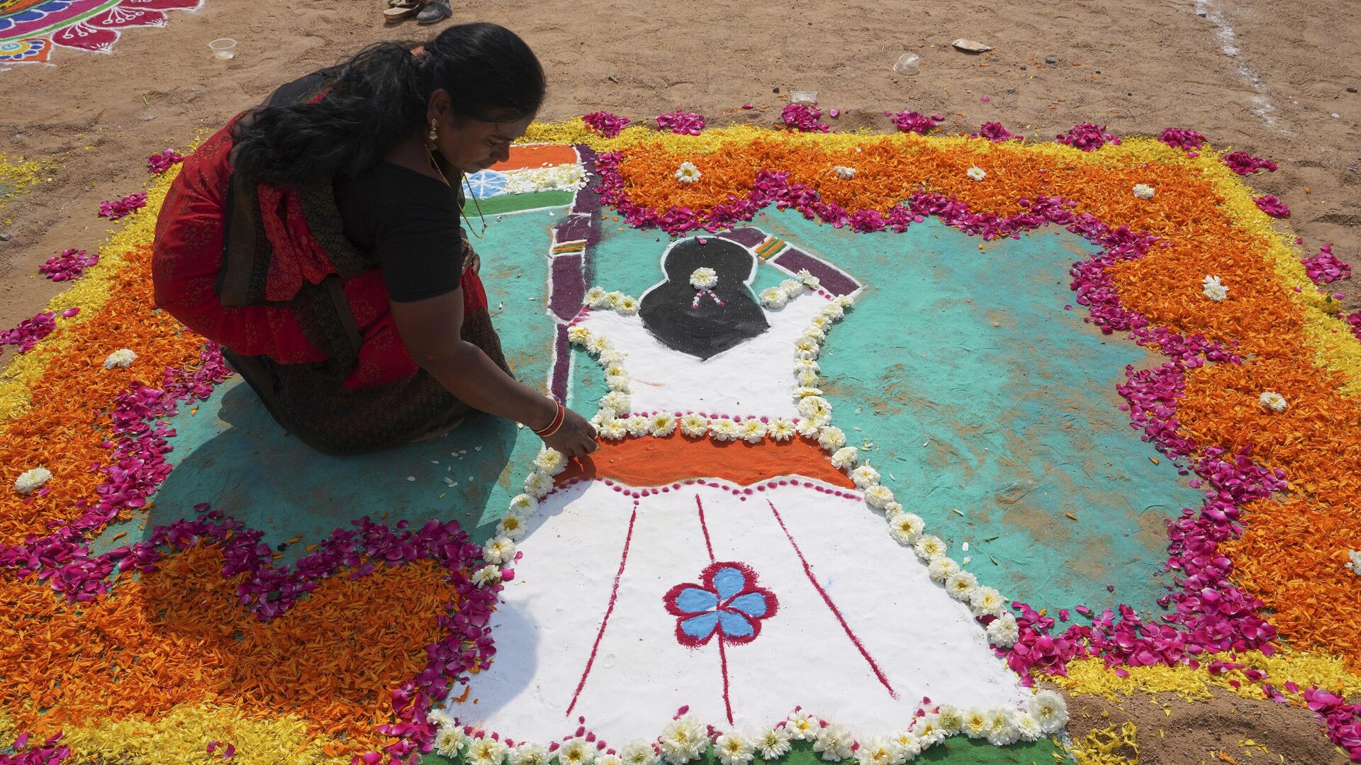 A woman prepares a Rangoli, a traditional art work of colored powder, during a rangoli competition on the eve of Makar Sankranti festival in Hyderabad, India, Friday, Jan. 13, 2023. - Sputnik India, 1920, 16.03.2023