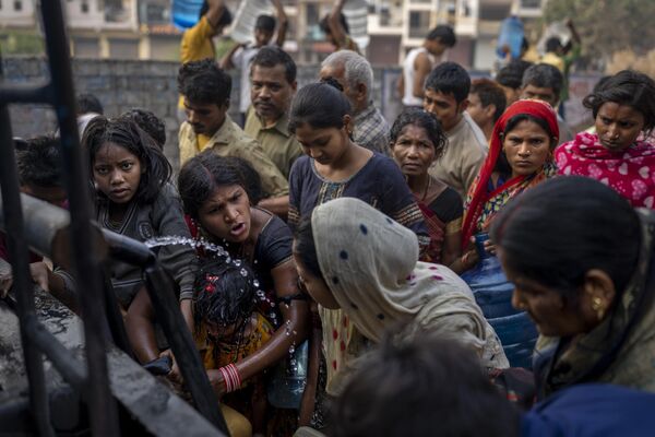 Women argue as they collect drinking water from a mobile water tanker on World Water Day in a residential area in New Delhi, India, Wednesday, March 22, 2023. - Sputnik भारत