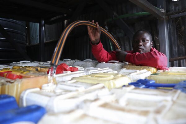 A water vendor fills water containers from a tanker in the Kibera slum of Nairobi, Kenya on Tuesday, March 21, 2023. - Sputnik भारत