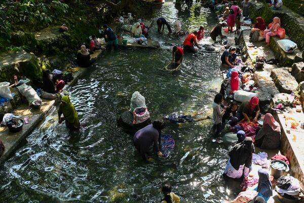 People wash their clothes in a public pool of spring water in Japakeh, Indonesia's Aceh province on March 22, 2023, during the World Water Day. - Sputnik भारत