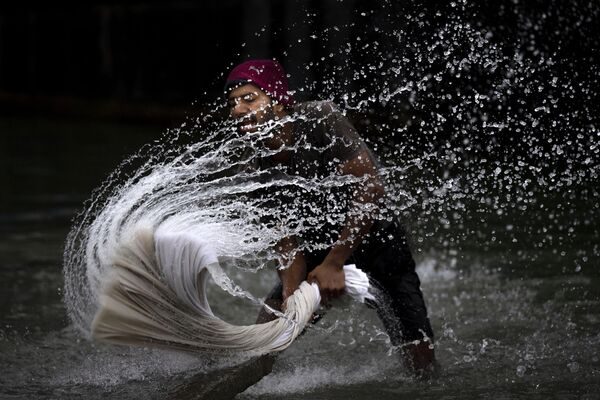 A washerman washes clothes on the banks of the river Brahmaputra on World Water Day in Guwahati, India, Wednesday, March 22, 2023. - Sputnik भारत