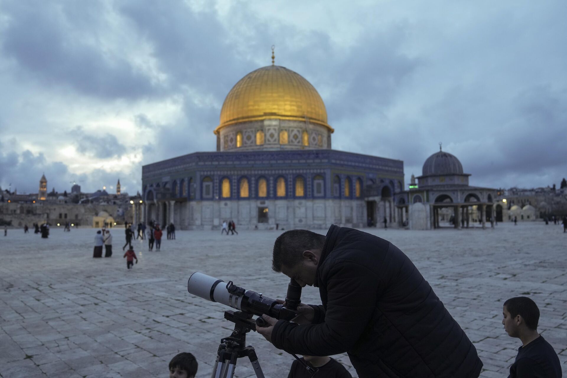A man observes the moon through a telescope next to the Dome of Rock Mosque at the Al-Aqsa Mosque compound in Jerusalem's Old City, Tuesday, March 21, 2023. - Sputnik India, 1920, 16.10.2023