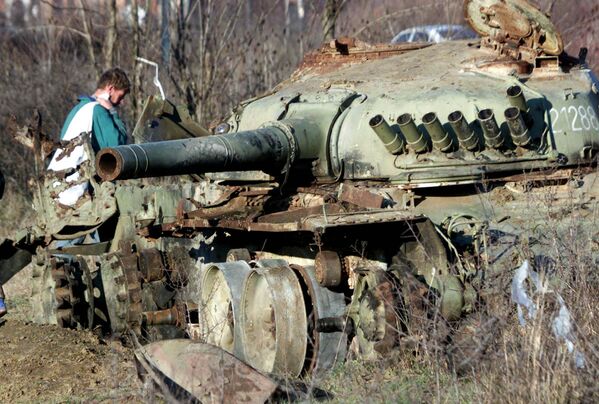 Этнический албанец проходит мимо танка югославской армии, уничтоженного во время бомбардировок НАТО в городе Клина на западе Косово - Sputnik India