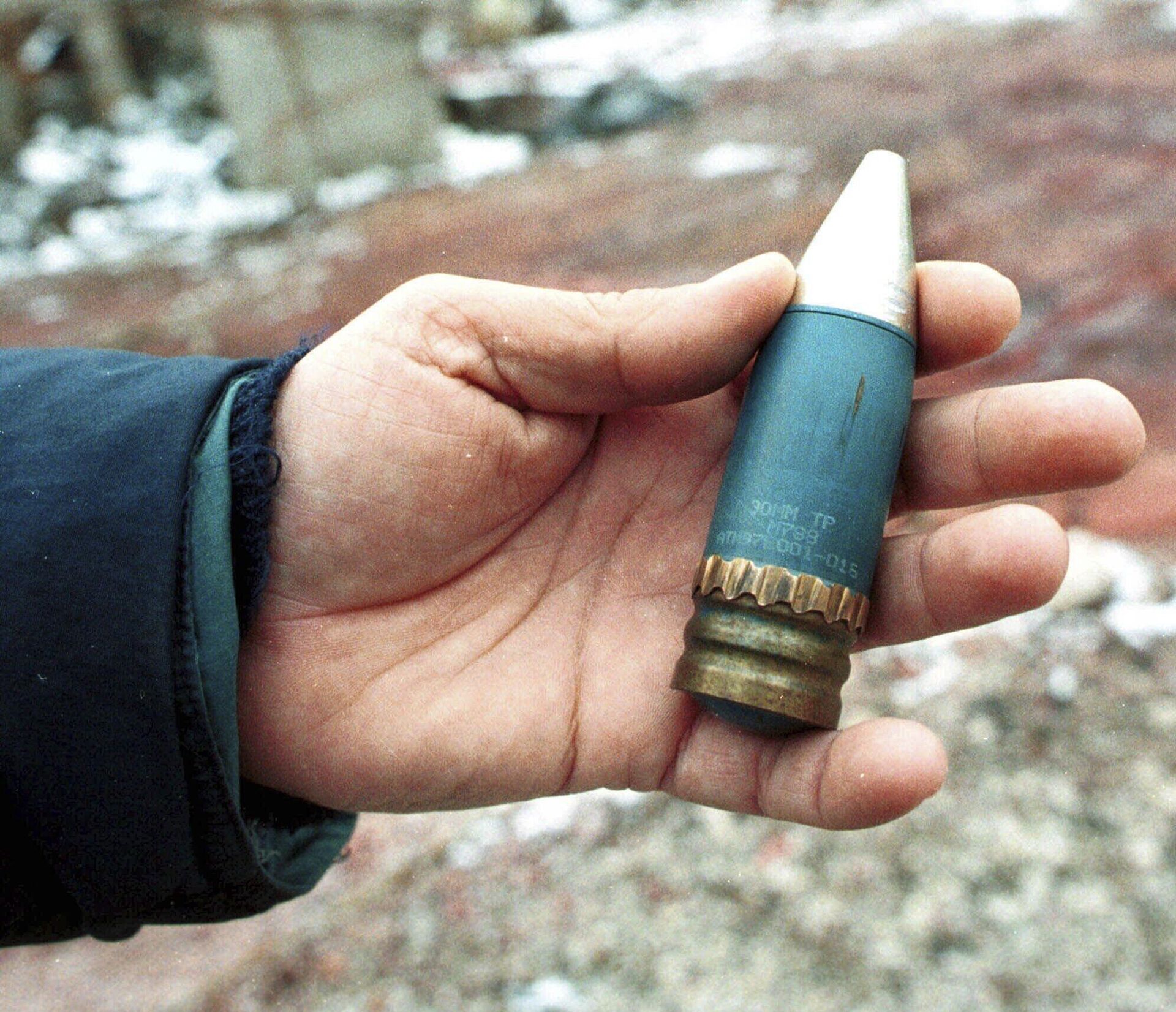 A member of a radiation team holds a 30mm armor-piercing shell containing depleted uranium, used by NATO during air strikes on Bosnia in 1995, which was found in a former military factory in the suburb of Vogosca, near Sarajevo, Jan. 15, 2001. - Sputnik भारत, 1920, 04.09.2023
