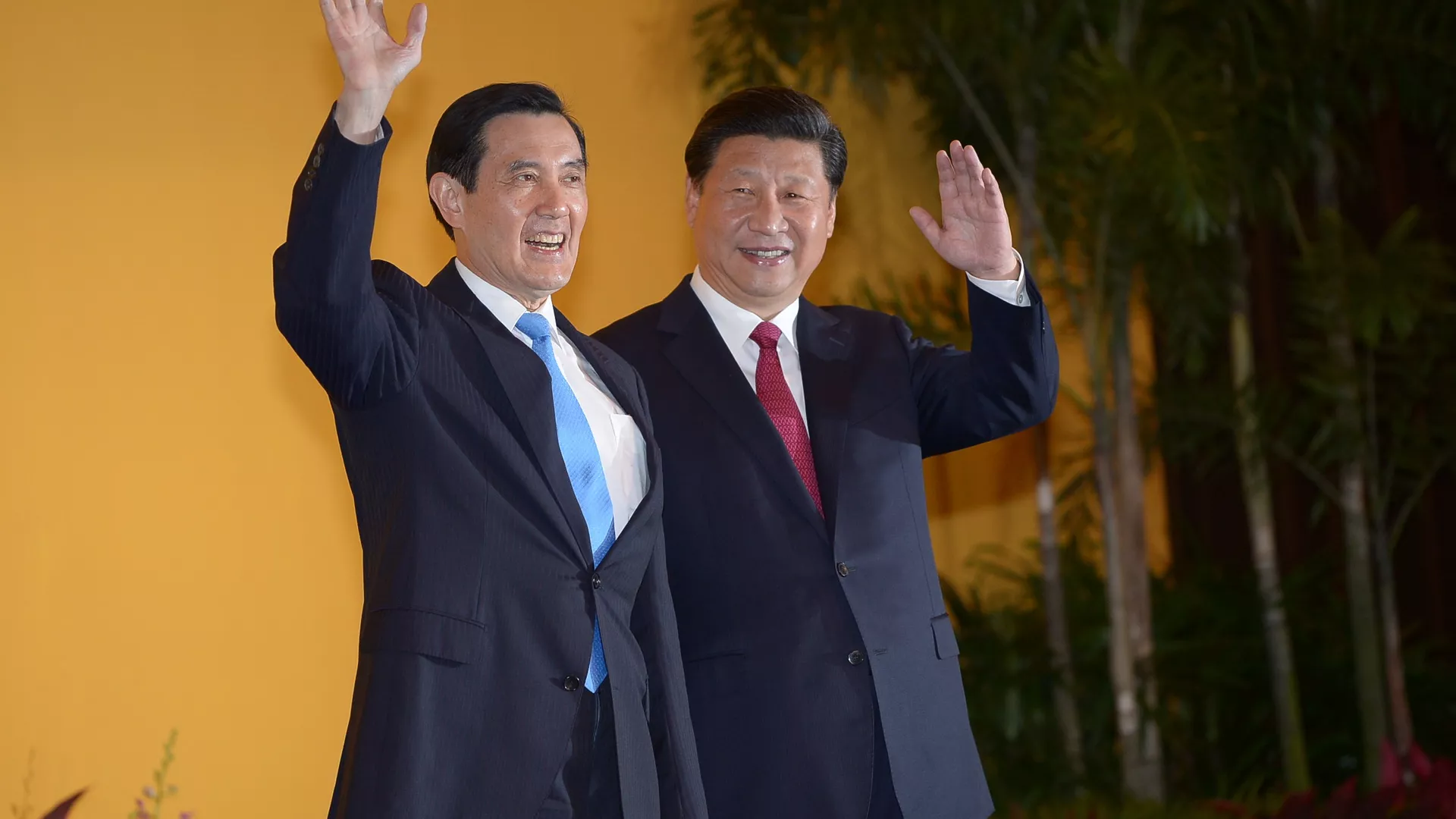 Chinese President Xi Jinping and Taiwan President Ma Ying-jeou wave to journalists before their meeting at Shangrila hotel in Singapore on November 7, 2015