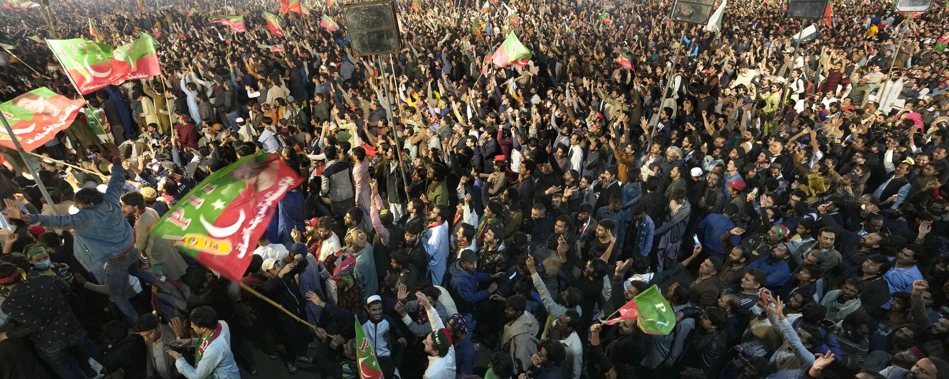 Supporters of former Prime Minister Imran Khan listen to his speech during a rally in Lahore, Pakistan, Sunday, March 26, 2023, to pressure the government of Shahbaz Sharif to agree to hold snap elections. - Sputnik India, 1920, 27.03.2023