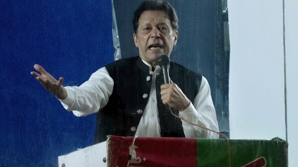 Protected by a bulletproof barrier, former Prime Minister Imran Khan speaks during a rally in Lahore, Pakistan, Sunday, March 26, 2023, to pressure the government of Shahbaz Sharif to agree to hold snap elections. - Sputnik India