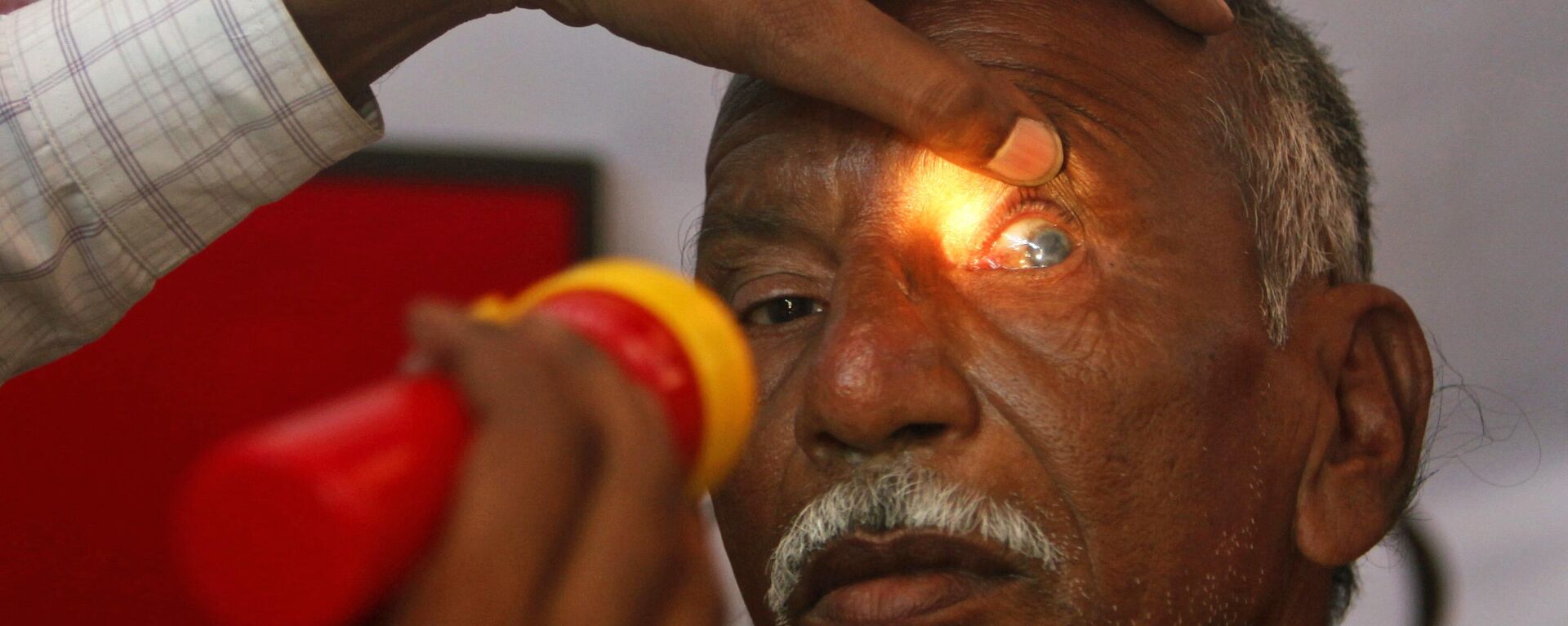 An Indian optician checks the eye of an elderly man at a free check-up camp at a shanty town to mark World Sight Day in Hyderabad, India, Thursday, Oct. 14, 2010. - Sputnik India, 1920, 28.03.2023