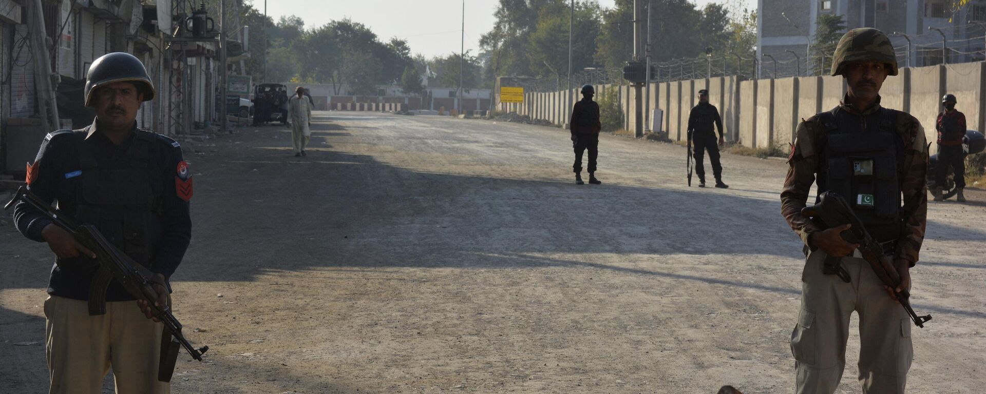 Security officials guard a blocked road leading to a counter-terrorism center after security forces starting to clear the compound seized earlier by Pakistani Taliban militants in Bannu, a northern district in the Pakistan's Khyber Pakhtunkhwa province, Tuesday, Dec. 20, 2022. - Sputnik भारत, 1920, 20.01.2024