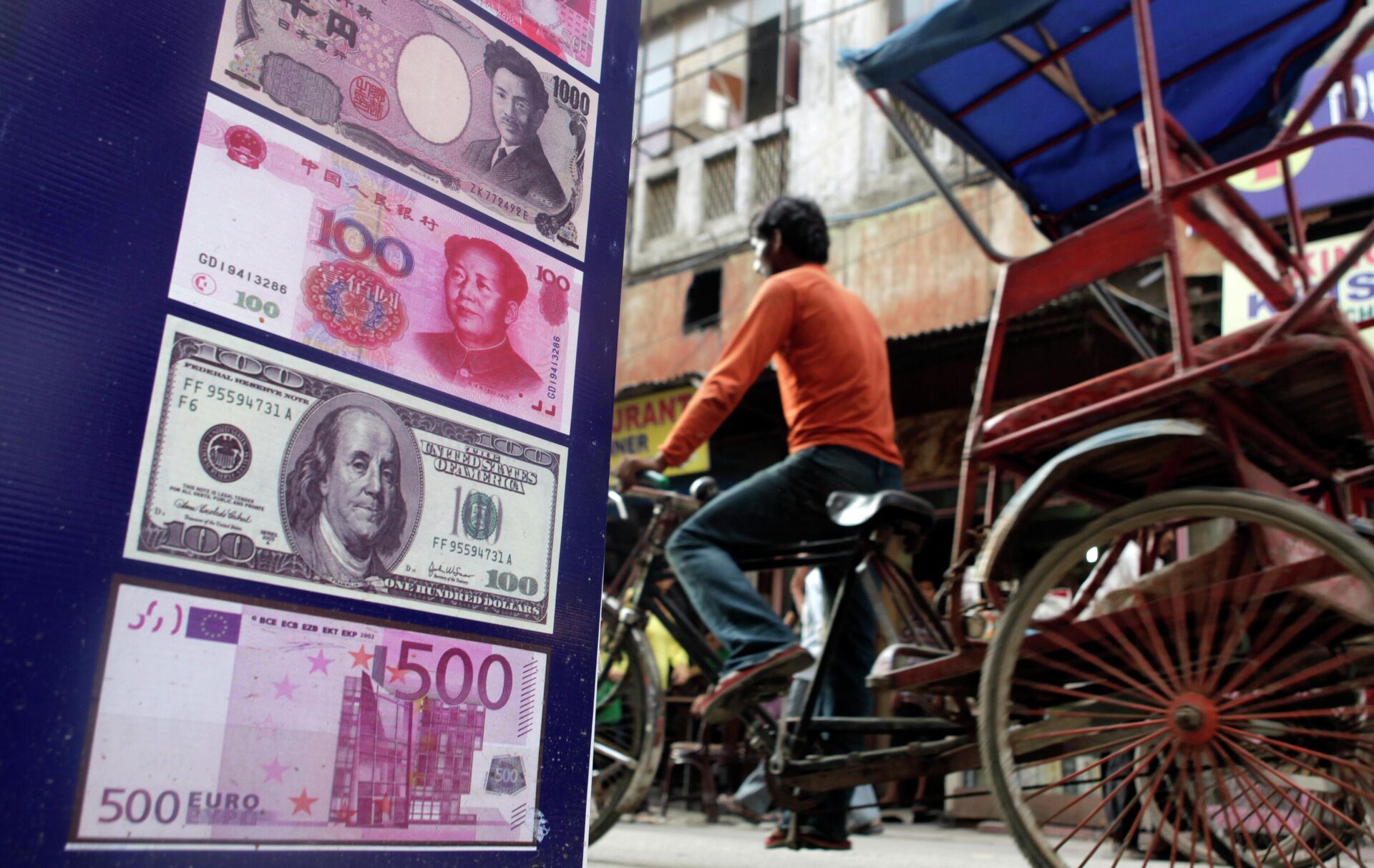 An Indian rickshaw driver rides past a foreign currency exchange shop in New Delhi, India,Thursday, Aug. 22, 2013. - Sputnik India, 1920, 04.10.2023