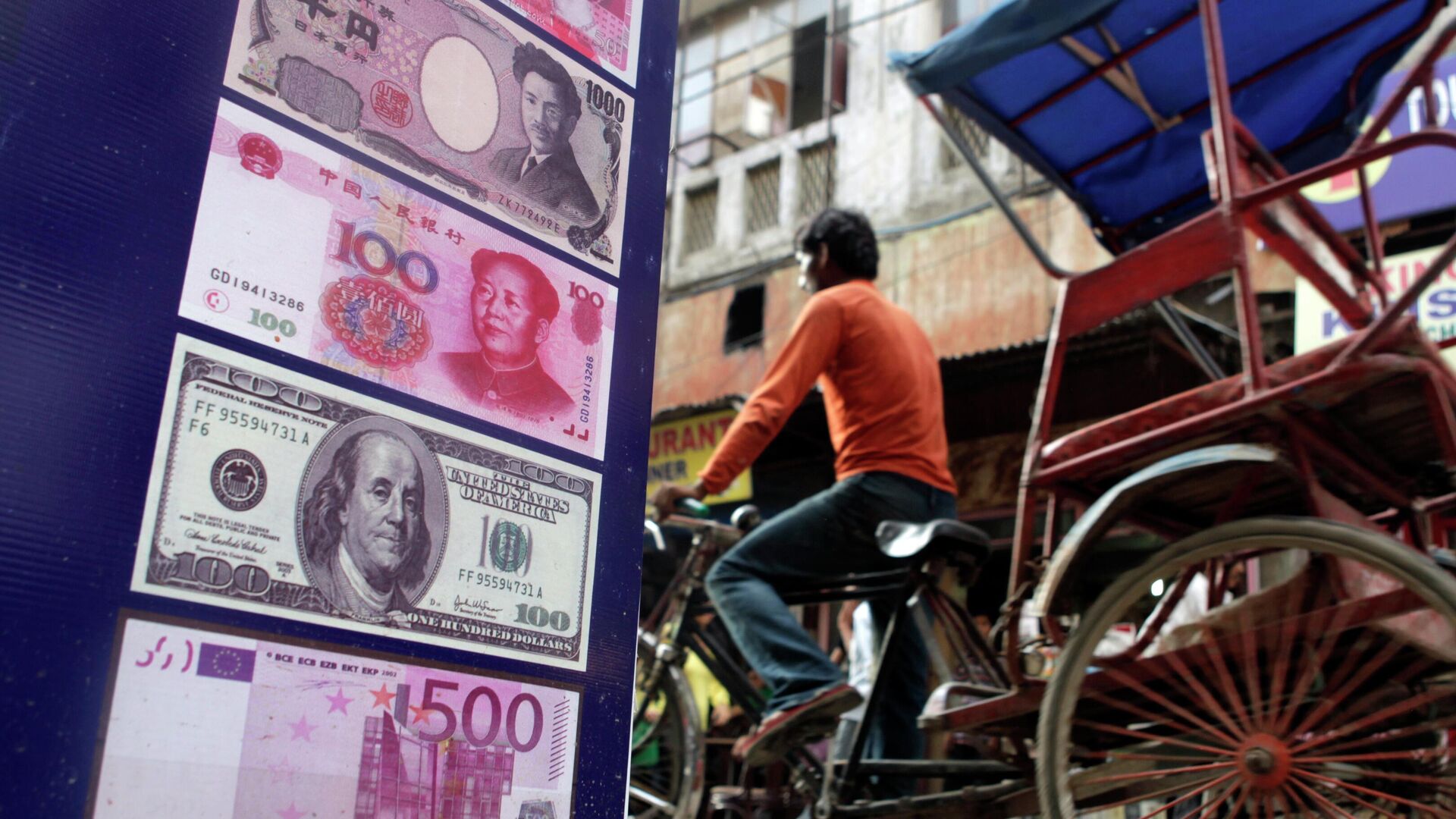 An Indian rickshaw driver rides past a foreign currency exchange shop in New Delhi, India,Thursday, Aug. 22, 2013. - Sputnik India, 1920, 16.05.2023