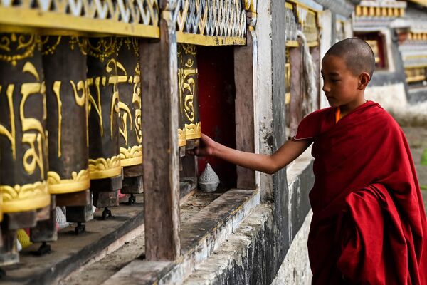 A young Buddhist monk spins prayer wheels at the Tawang monastery in Tawang, a town in the northeast Indian state of Arunachal Pradesh on April 5, 2023. (Photo by Arun SANKAR / AFP) - Sputnik India