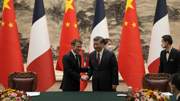 China’s President Xi Jinping (R) shakes hands with his French counterpart Emmanuel Macron after the signing ceremony in Beijing on April 6, 2023. - Sputnik India