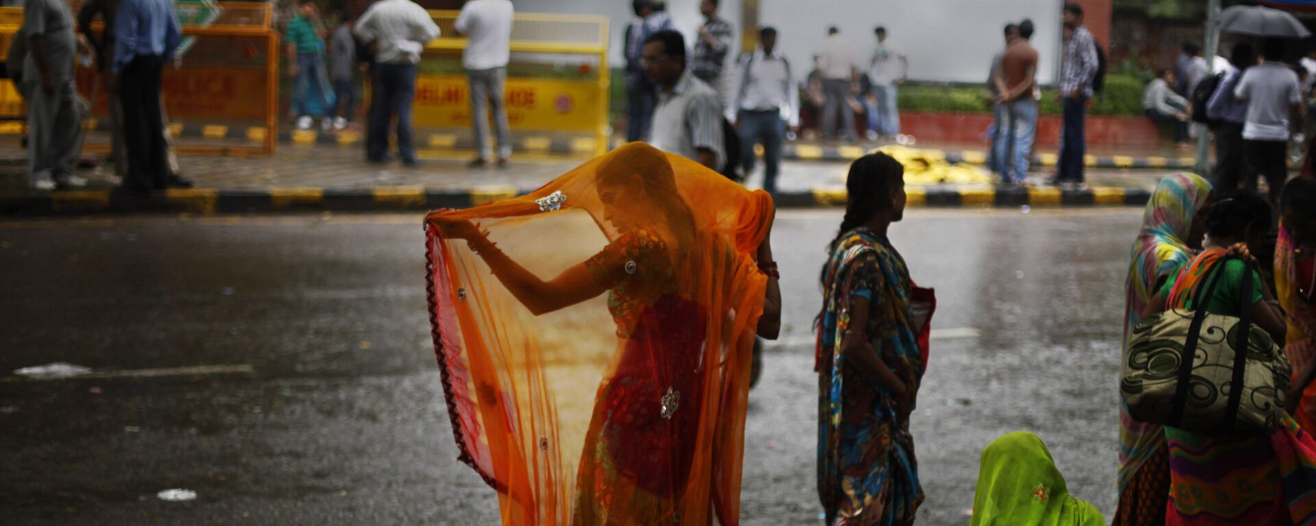An Indian woman adjusts her sari after she got wet in the monsoon rains in New Delhi, India, Wednesday, Aug. 7, 2013 - Sputnik भारत, 1920, 10.04.2023