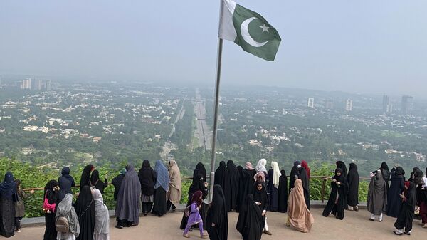 A Pakistani flag flies on a lookout as women take in the view of Islamabad, Pakistan, Wednesday, July 27, 2022. - Sputnik भारत