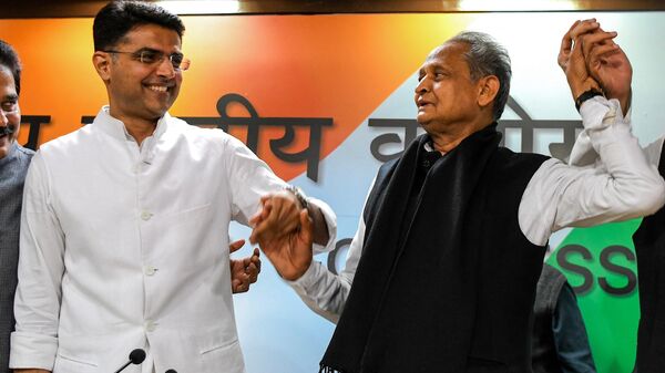 Newly-appointed Rajasthan chief minister Ashok Gehlot (R) and his newly-appointed deputy Sachin Pilot gesture as they hold hands during a press conference at the All India Congress Committee offices in New Delhi on December 14, 2018. - Sputnik India