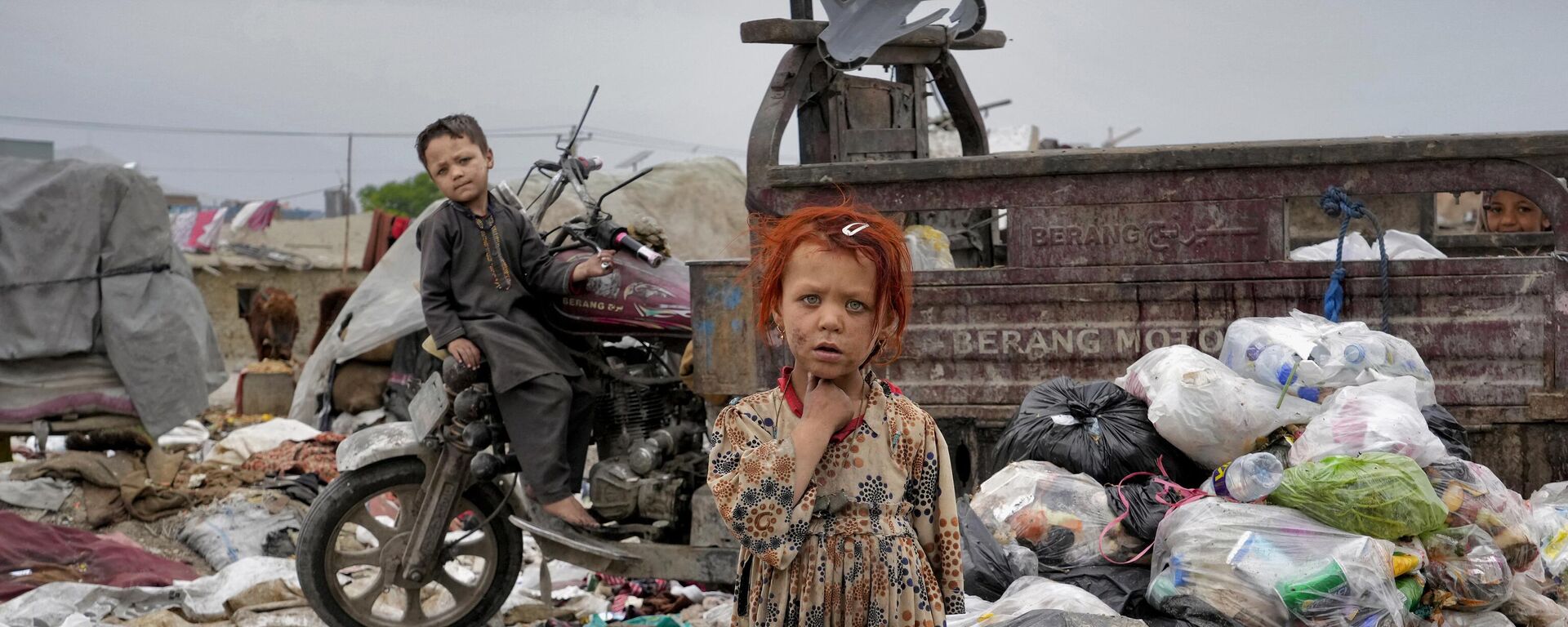 Two children stand in piles of garbage next to their home, in Kabul, Afghanistan, Monday, April 18, 2022. - Sputnik India, 1920, 12.04.2023