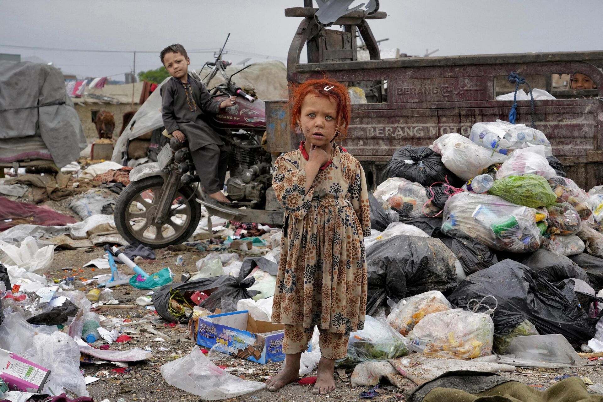 Two children stand in piles of garbage next to their home, in Kabul, Afghanistan, Monday, April 18, 2022. - Sputnik India, 1920, 05.10.2023