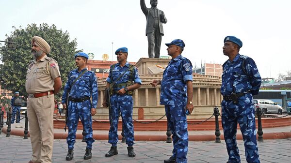 Security personnel stand guard near a statue of India's social reformer and architect of its constitution B.R. Ambedkar - Sputnik भारत