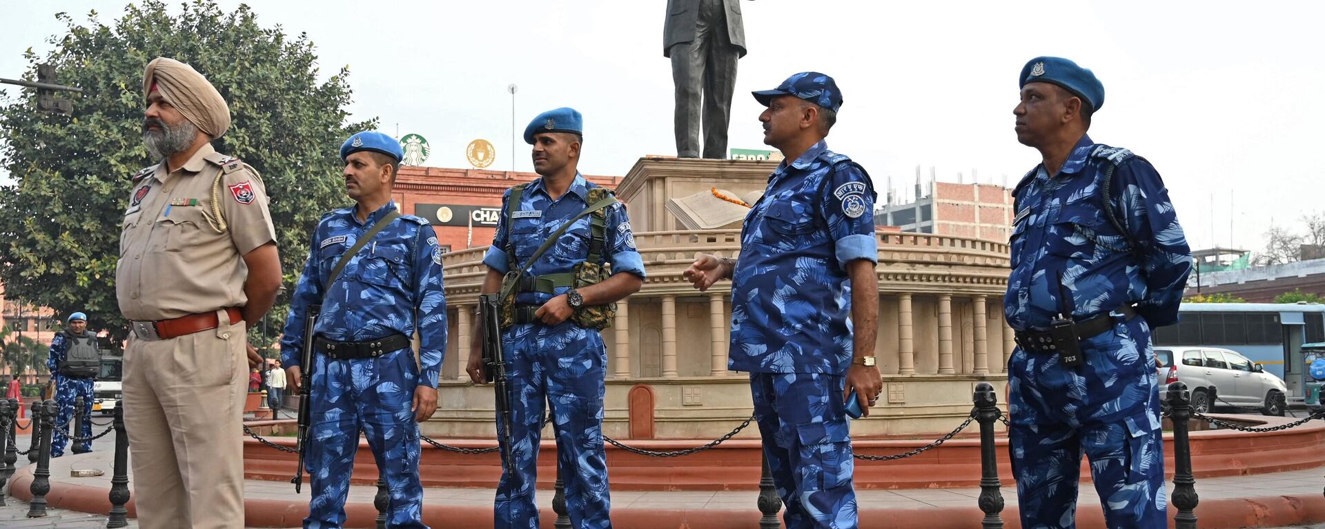 Security personnel stand guard near a statue of India's social reformer and architect of its constitution B.R. Ambedkar - Sputnik भारत, 1920, 12.04.2023