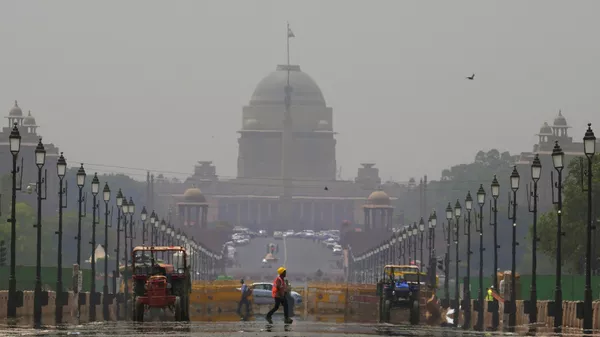 A construction worker walks across a mirage created on a road due to very hot weather in New Delhi, India, Monday, May 2, 2022. - Sputnik भारत