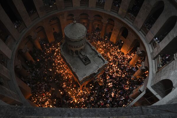 15 अप्रैल को ऑर्थडाक्स ईस्टर से एक दिन पहले यरूशलेम के पवित्र दरगाह वाले चर्च में पवित्र अग्नि दिखाई देने की परंपरा के अवसर पे ईसाई लोग (AP Photo/Tsafrir Abayov) - Sputnik भारत