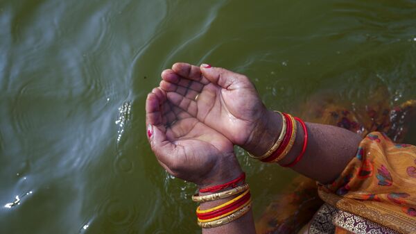A Hindu devotee performs rituals at Sangam, the confluence of rivers the Ganges and the Yamuna, in Prayagraj, India, Wednesday, March 22, 2023. - Sputnik भारत