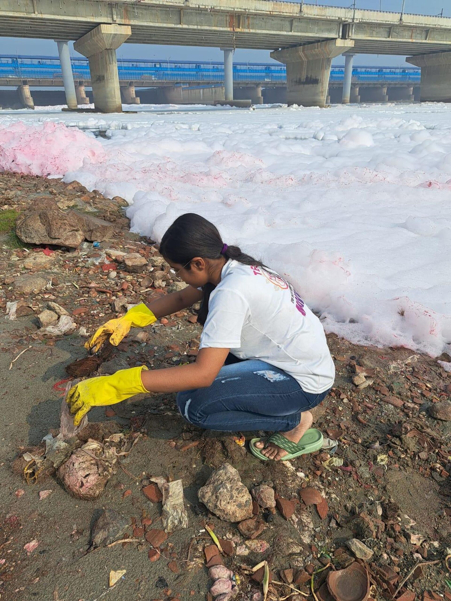 YSS Foundation volunteer collecting garbage at Kalindi Kunj Ghat, Delhi, as  river water is covered by toxic foam - Sputnik India, 1920, 18.04.2023