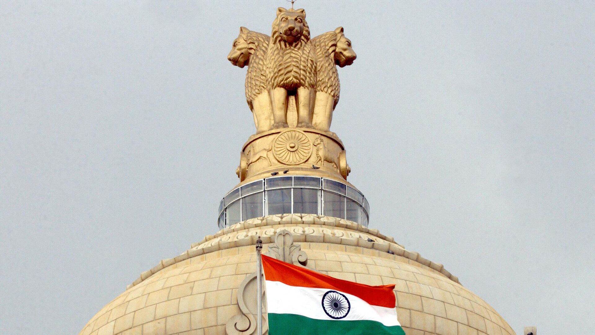 The Indian national flag flies in front of the Indian national emblem, lying atop the Vidhana Soudha State assembly in Bangalore - Sputnik India, 1920, 06.05.2023