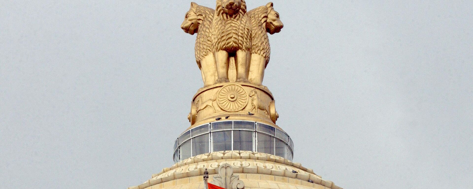 The Indian national flag flies in front of the Indian national emblem, lying atop the Vidhana Soudha State assembly in Bangalore - Sputnik India, 1920, 21.04.2023