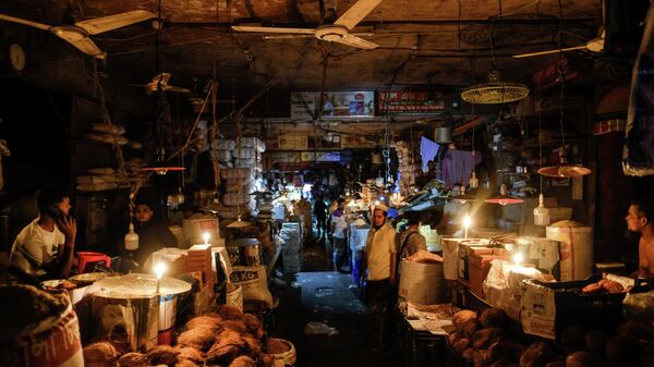Vendors light candles at a market after a failure in Bangladesh's national power grid plunged much of the country into a blackout in Dhaka, Bangladesh, Tuesday, Oct.4, 2022. - Sputnik India