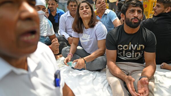 Indian wrestlers Bajrang Punia (2R) and Vinesh Phogat (C) take part in an ongoing protest against the Wrestling Federation of India (WFI) in New Delhi on April 23, 2023, following allegations of sexual harassment to athletes by members of the WFI. - Sputnik India