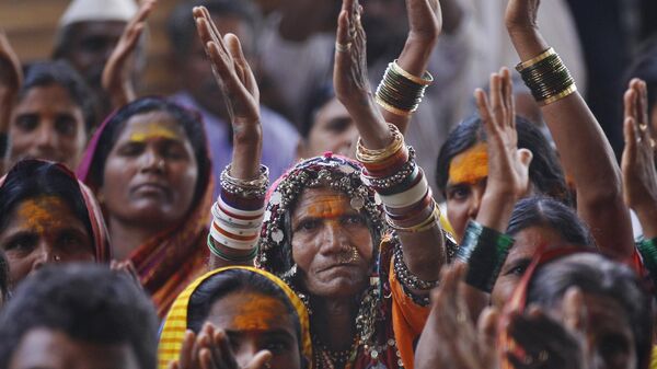 An indigenous Indian woman, center, joins others in applauding a speaker during a protest by backward Hindu communities demanding equal rights in Bangalore, India, Wednesday, Feb. 11, 2015. - Sputnik India