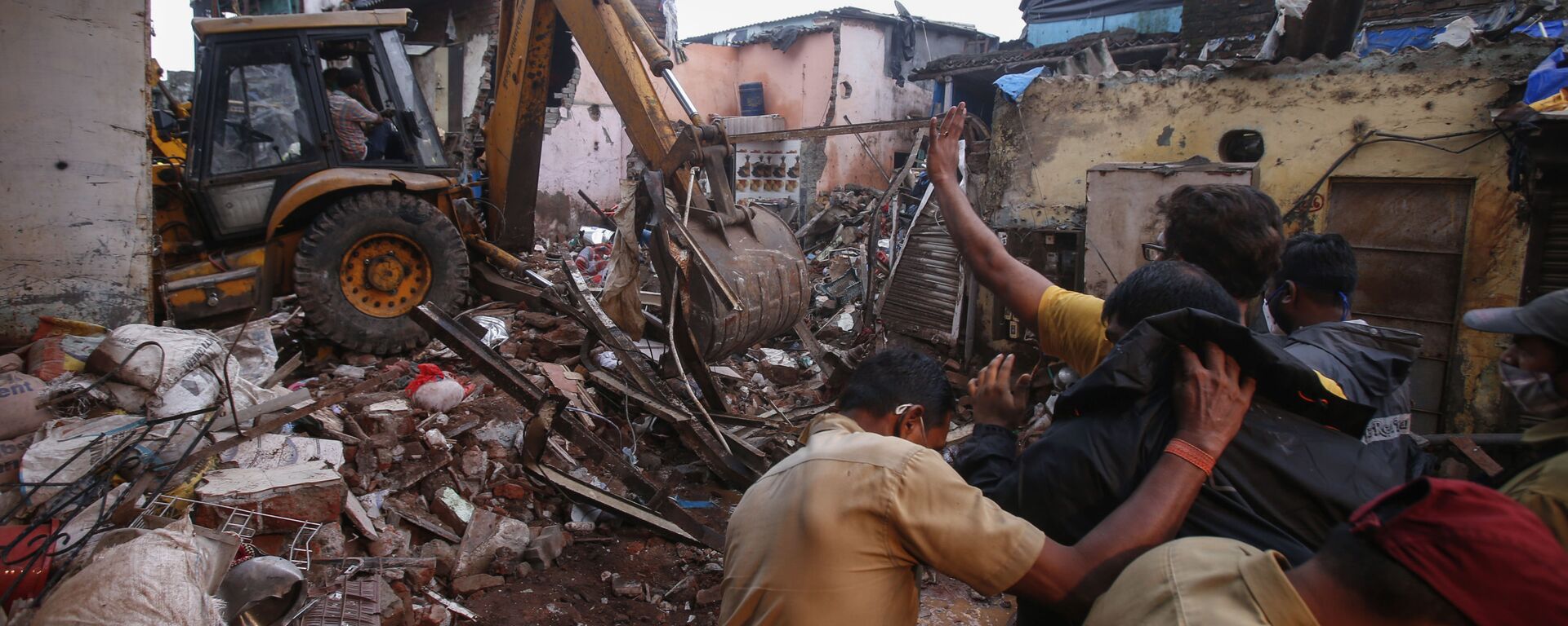 Rescuers clear the debris to find any residents possibly still trapped after a three-story dilapidated building collapsed following heavy monsoon rains n Mumbai, India, Thursday, June 10, 2021 - Sputnik India, 1920, 30.04.2023