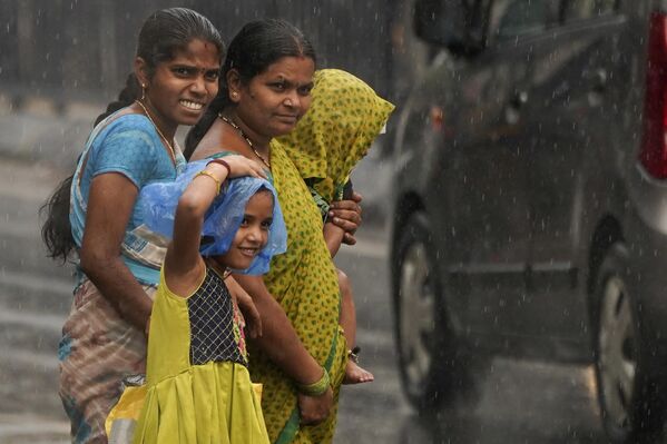 People wait to cross a busy road during pre-monsoon rains in Hyderabad, India, Monday, May 1, 2023. - Sputnik India