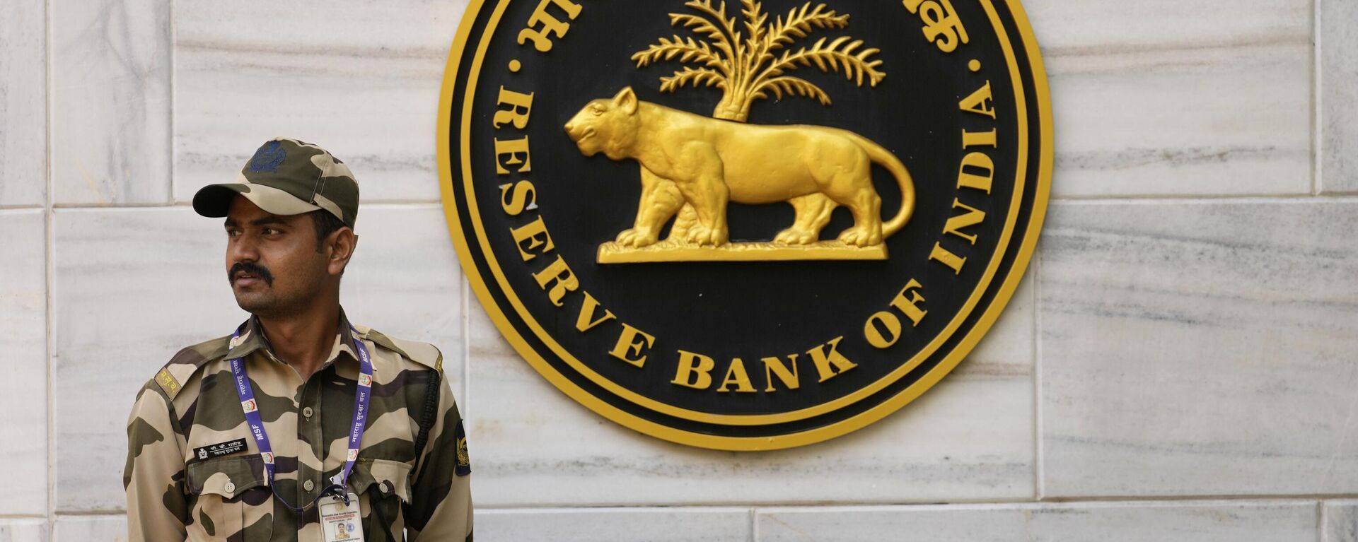 A Security guard stands outside Reserve Bank of India (RBI) headquarters in Mumbai, India, Thursday, April 6, 2023. - Sputnik India, 1920, 22.05.2023