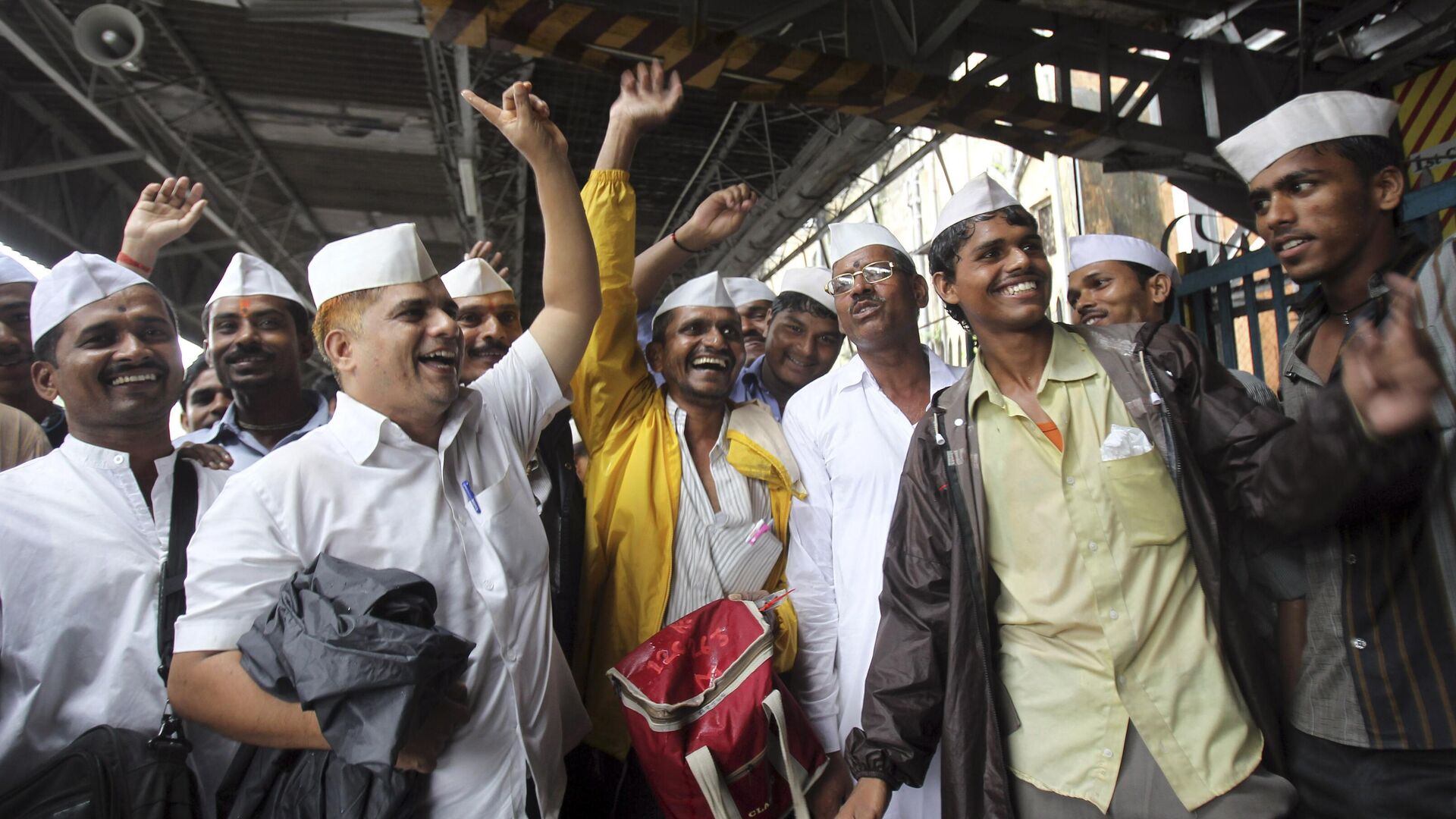 Dabbawalas, or lunchbox delivery men, pass out sweets in celebration of the birth of the Prince of Cambridge, the son of Britain's Prince William and Kate, Duchess of Cambridge, at a railway platform in Mumbai, India, Tuesday, July 23, 2013. - Sputnik India, 1920, 03.05.2023