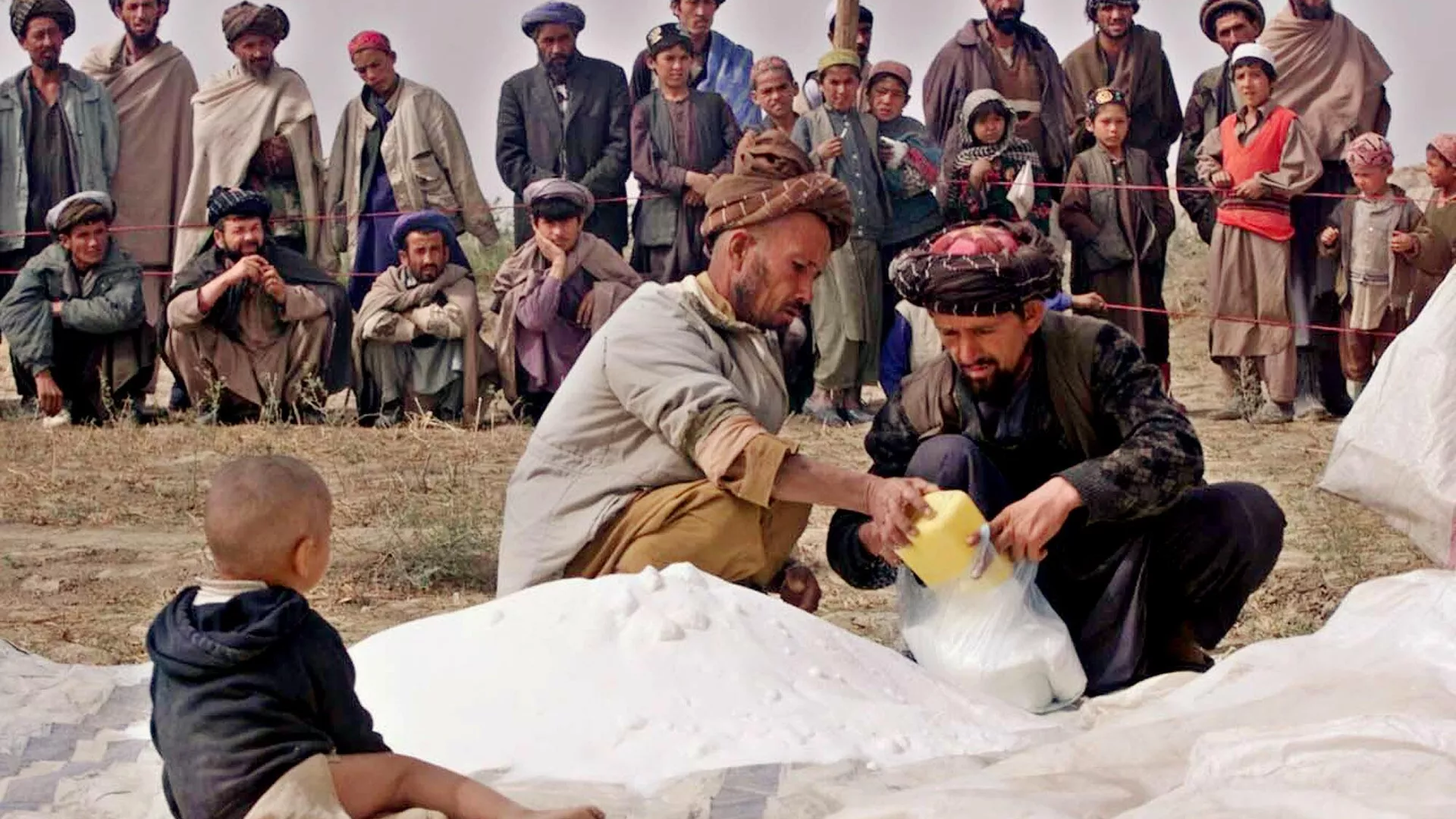 Afghans receive sugar and flour as a part of humanitarian aid