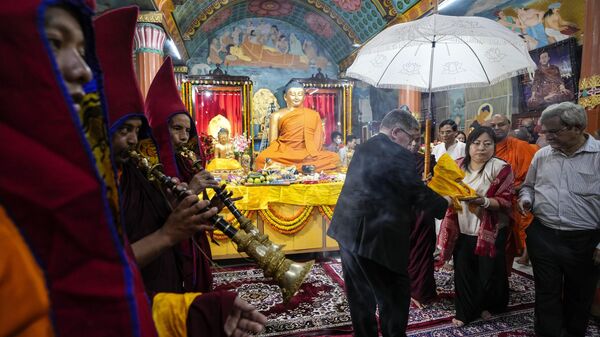 Sonar Pelzom, second right, Deputy Consul General of Bhutan and a representative of British Deputy High Commission carry a relic in a procession as Buddhist monks blow traditional instruments during Buddha Purnima festival inside a temple in Kolkata, India, Friday, May 5, 2023. - Sputnik India