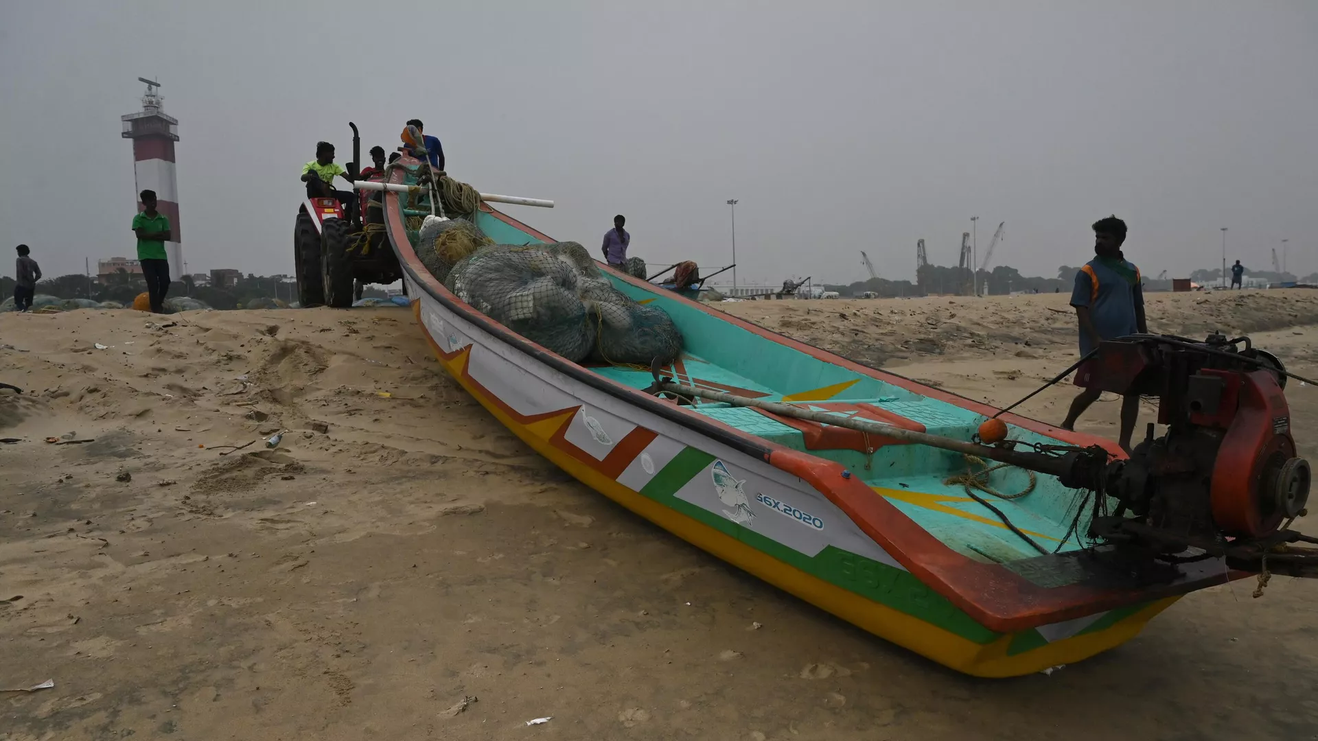 Fishermen pull their boat out of the Indian Ocean