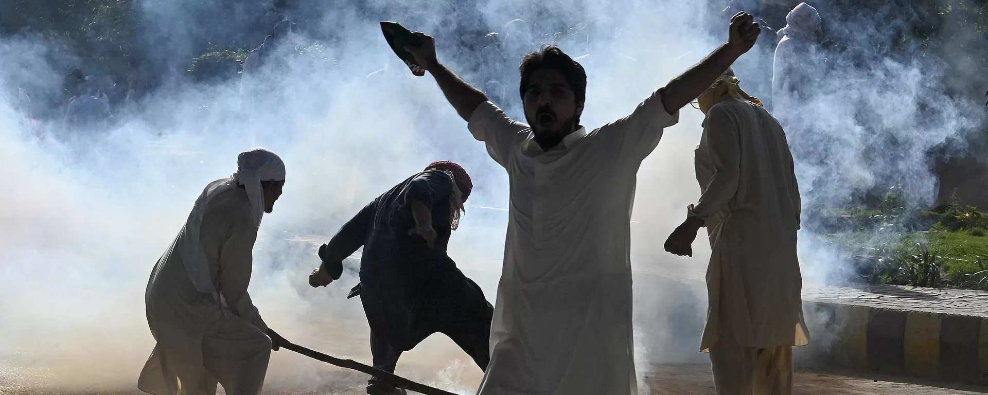 Pakistan Tehreek-e-Insaf (PTI) party activists and supporters of former Pakistan's Prime Minister Imran clash with police amid teargas during a protest against the arrest of their leader, in Peshawar on May 9, 2023. - Sputnik India, 1920, 09.05.2023