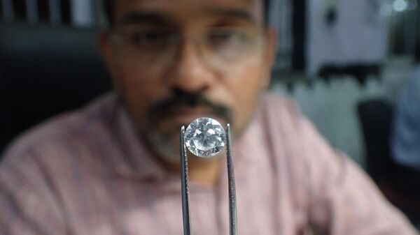 A worker checks a diamond at a diamond polishing workshop in Ahmedabad on January 10, 2023. - Sputnik भारत