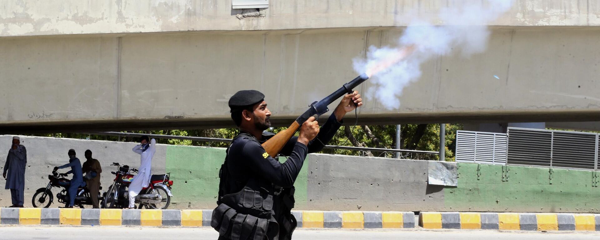 A police officer fires tear gas to disperse supporters of Pakistan's former Prime Minister Imran Khan protesting against the arrest of their leader, in Peshawar, Pakistan, Wednesday, May 10, 2023. - Sputnik India, 1920, 16.05.2023