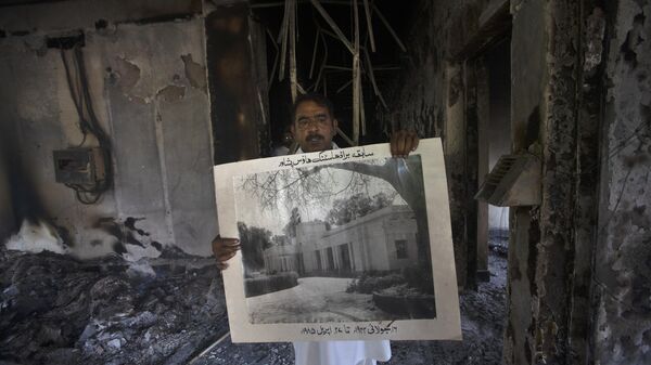 A government employee displays an old picture to media members inside the Radio Pakistan building burnt in the Wednesday's clashes between police and the supporters of Pakistan's former Prime Minister Imran Khan, in Peshawar, Pakistan, Thursday, May 11, 2023. - Sputnik India