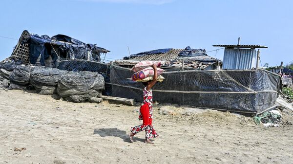 A girl carries belongings as she returns from a shelter in Shahpori island on the outskirts of Teknaf on May 15, 2023, a day after the cyclone Mocha's landfall. - Sputnik India