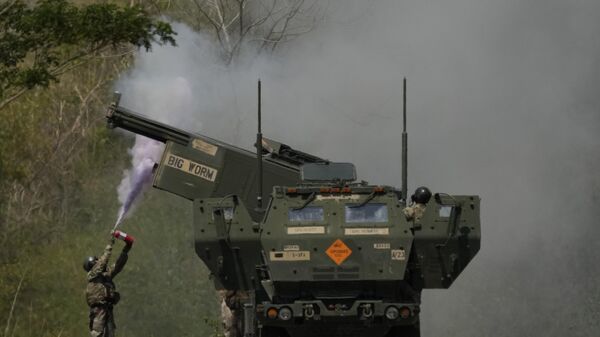 A US soldier extinguishes a fire on one fo the tubes on a U.S. M142 High Mobility Artillery Rocket System (HIMARS) after firing missiles during a joint military drill between the Philippines and the U.S. called Salaknib at Laur, Nueva Ecija province, northern Philippines on Friday, March 31, 2023. - Sputnik India