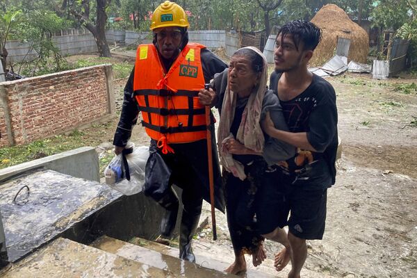 Спасатели помогают пожилой женщине добраться до убежища после шторма в Текнафе, Бангладеш - Sputnik भारत