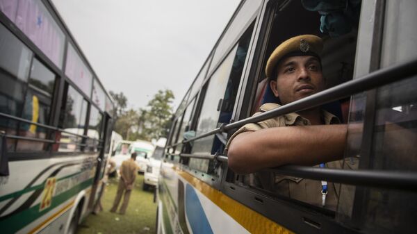 An Assam Police person sits in a vehicle as he waits to head for poll duty on the eve of  second phase of state elections in Morigaon, Assam, India, Wednesday, March 31, 2021. - Sputnik India